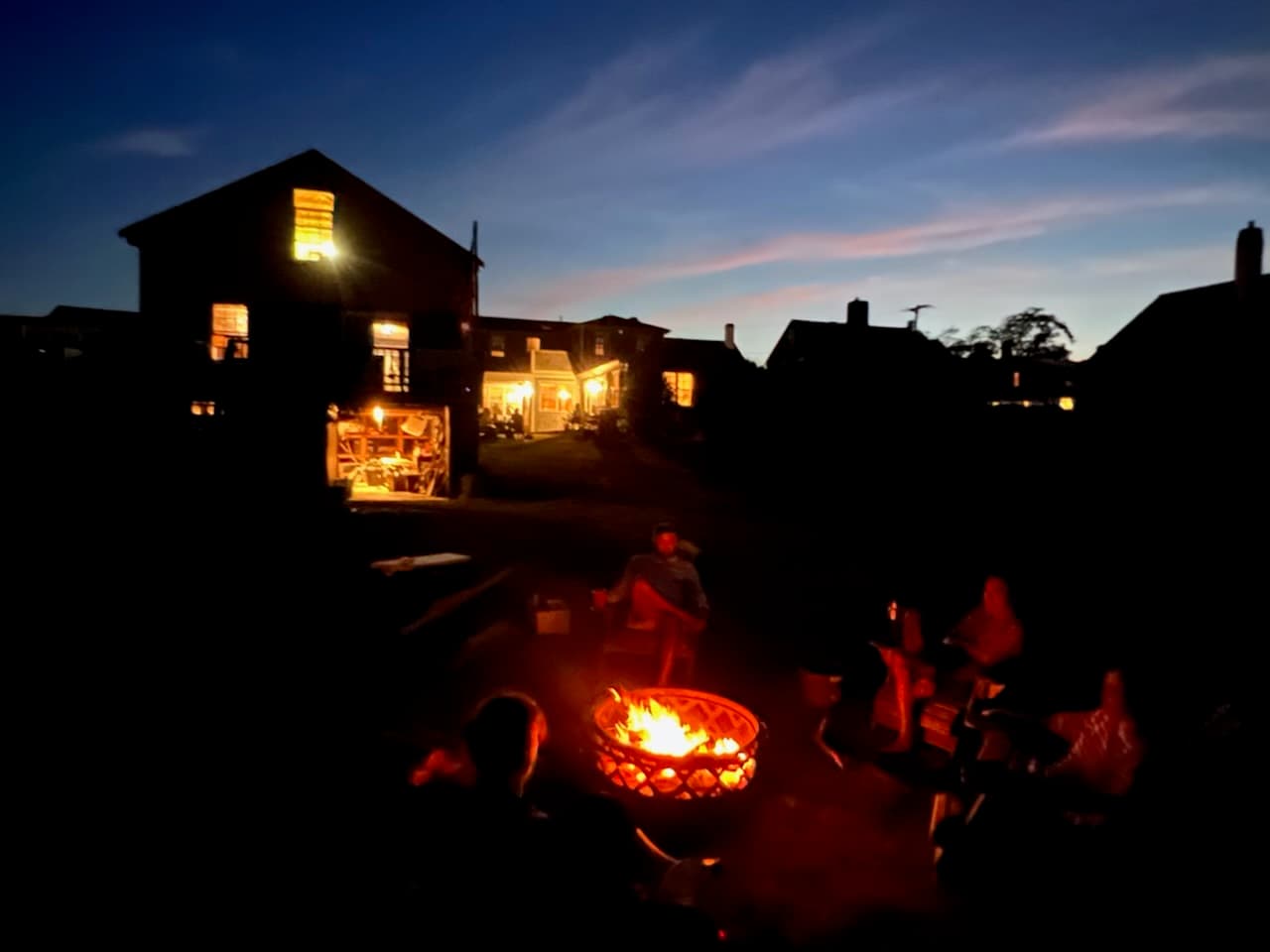 The Long family seated together around a campfire at dusk