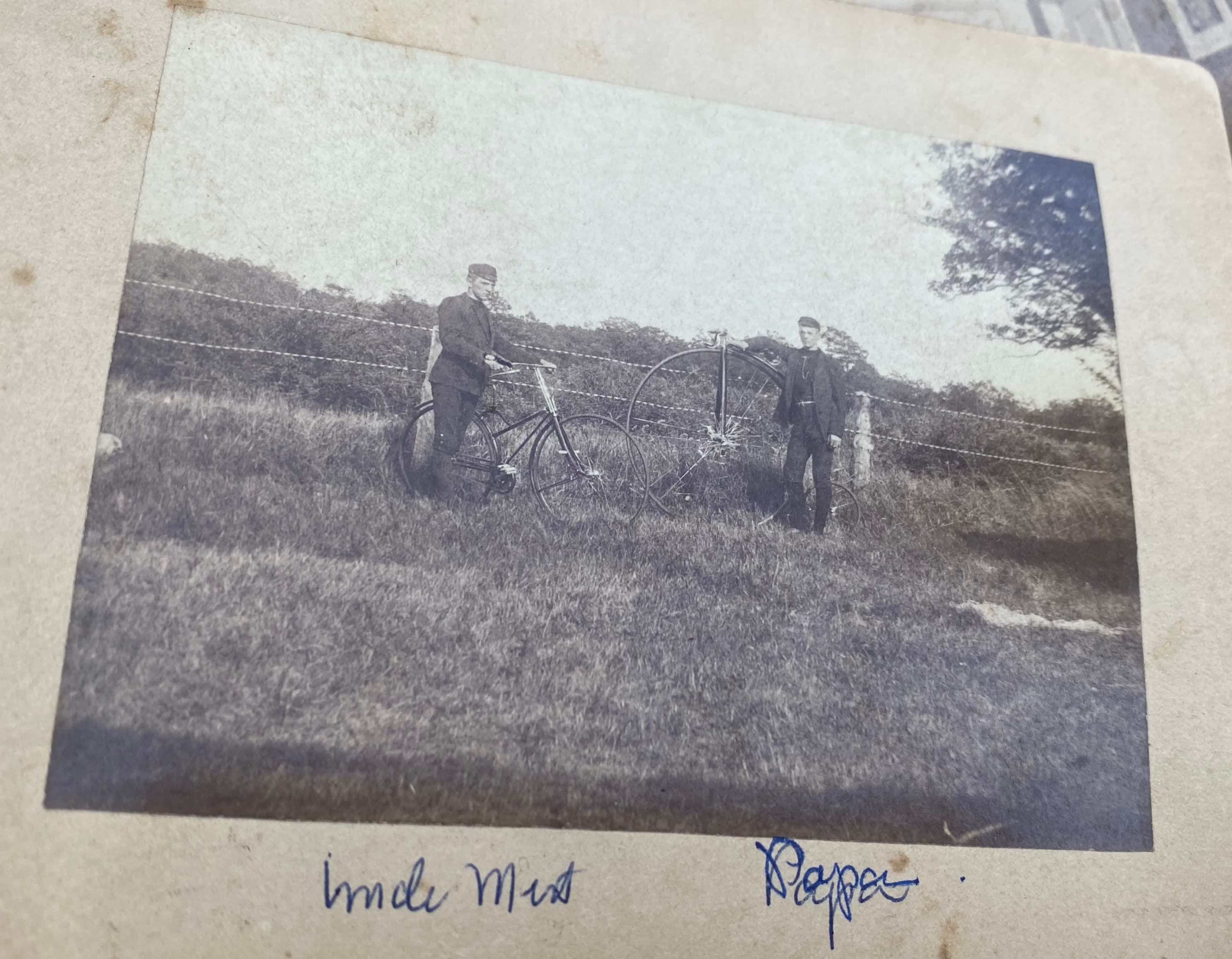 Two men with bicycles in field